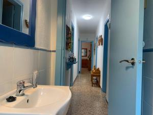 La salle de bains est pourvue d'un lavabo et d'une porte bleue. dans l'établissement La casa de l'Estany, à L'Ametlla de Mar