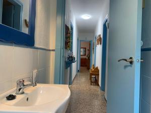 a bathroom with a sink and a blue door at La casa de l'Estany in L'Ametlla de Mar +52 photos
