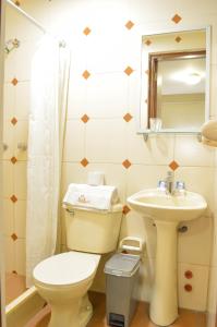 a bathroom with a toilet and a sink at Takana Inn in Tacna