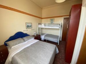 a bedroom with a bed and a bunk bed at Friends Hotel in Sandown