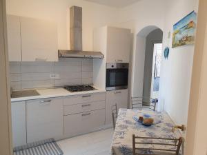 a kitchen with white cabinets and a table with a plate on it at Casa vacanza in riva al mare in Arzachena