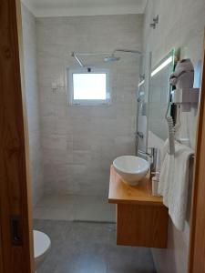 Un baño con lavabo, inodoro y ducha. en Hotel Ribeira Grande, en Ribeira Grande