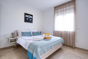a bedroom with a bed with a bowl of fruit on it at Apartments Bonaca with Jacuzzi in Privlaka