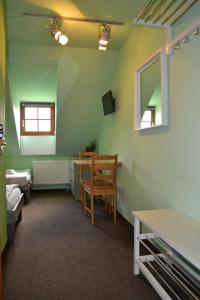 Cette chambre comprend une table, une chaise et un miroir. dans l'établissement Hotel Antoň, à Telč