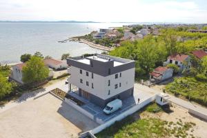 an aerial view of a white house on the water at Apartments Bonaca with Jacuzzi in Privlaka