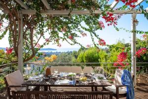 een tafel en stoelen op een patio met bloemen bij Stellar Villa Private Pool-Sea View in Porto Cheli