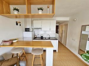 a small kitchen with a wooden table and chairs at Coqueto estudio cerca del mar in Almerimar