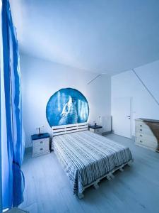 a bedroom with a bed with a painting on the wall at Bau!House in Piombino