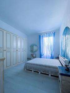a blue bedroom with a bed and a blue light at Bau!House in Piombino
