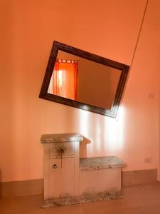 a mirror on the wall of a bathroom with a sink at Bau!House in Piombino