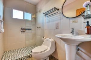 a bathroom with a toilet and a sink and a mirror at Bocas Paradise Hotel in Bocas del Toro