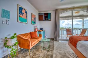 um quarto com uma cama, uma cadeira e uma varanda em Bocas Paradise Hotel em Bocas del Toro