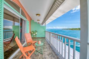 a balcony with chairs and a view of the ocean at Bocas Paradise Hotel in Bocas del Toro