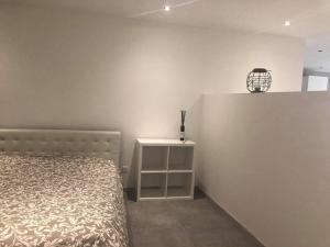 - une chambre avec un lit et un mur blanc dans l'établissement Guest house à Chaudfontaine, à Chaudfontaine
