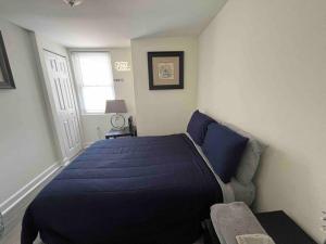 a bedroom with a blue bed and a couch at A Sports Fan Getaway in Baltimore