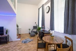 sala de estar con mesa y reloj en la pared en Bella Mia - Entire Apartment near Liszt Ferenc Ter, en Budapest