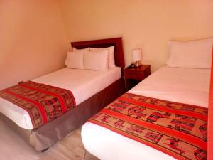 Dos camas en una habitación de hotel con cama sidx sidx sidx sidx en hostal casa talitha, en San Pedro de Atacama