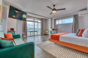 a bedroom with a bed and a tv and a couch at Bocas Paradise Hotel in Bocas del Toro