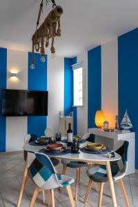 uma sala de jantar com paredes azuis e uma mesa e cadeiras em Relaxroombeach em Anzio