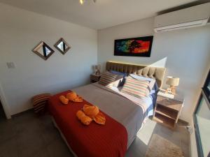 un dormitorio con una cama con dos animales de peluche en Departamento Vista a Cordillera Premium en Godoy Cruz
