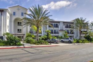 a building with palm trees in front of a parking lot at 689 - Steps to the Resort, Peaceful Studio with free Wifi & Parking in Encinitas