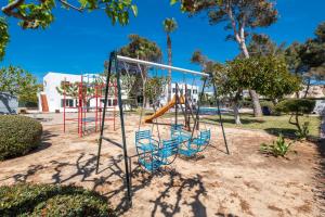 a playground with a slide in a park at Apartamentos Llebeig in Ciutadella