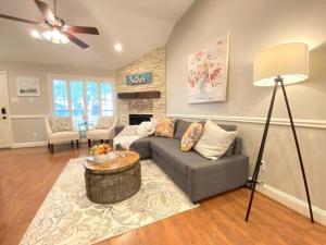 a living room with a gray couch and a fireplace at Comfortable Sleep 08 - Furnished Family Home with Spacious Backyard & Swing in Katy