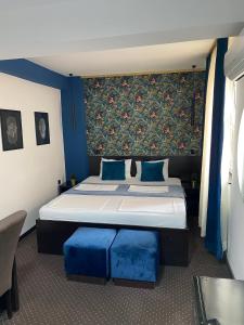 a bedroom with a large bed with blue pillows at 4 Rooms Apartments in Niš