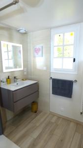 baño con lavabo, espejo y ventana en Chambre d'hôtes proche Chenonceau, en Chisseaux