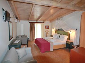 ヴァシリキにあるVassiliki Bay Hotelのベッドとソファ付きのホテルルーム
