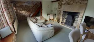 a living room with a white couch and a fireplace at Cupcake Cottage: Quintessential Cotswold Cottage in Nailsworth