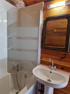 a bathroom with a sink and a toilet and a tub at Gite rustique en Centre Bretagne in Laniscat
