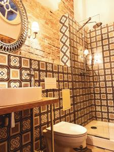 a bathroom with a toilet and a mirror at SĪMANIS Boutique Hotel in Kuldīga