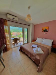 a bedroom with a large bed and a balcony at Studios Denis in Stavros