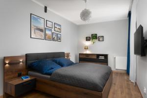 a bedroom with a bed with blue pillows at Apartament Marina Loft & Spa Sagaris Dziwnów in Dziwnów