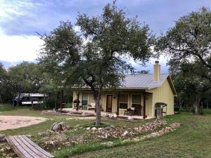 聖馬科斯的住宿－SpecialTies Cottage，院子中一棵树的小黄色房子