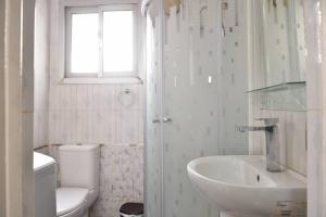 a white bathroom with a sink and a toilet at Sunny Apt In Downtown Cairo Near Tahrir Square in Cairo