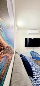 a bedroom with a bed with a painting on the wall at La casa al mare, Pittulongu in Olbia