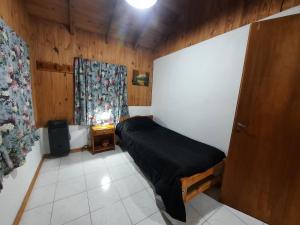 Habitación pequeña con cama y ventana en Cabaña Ayelen en Esquel