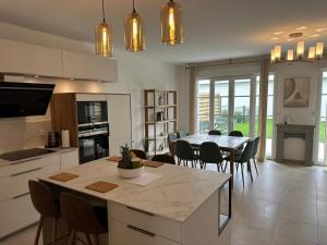 a kitchen and dining room with a table and chairs at Villa, Disneyland Paris, vallée village ,Paris ,garden , Syline Home in Serris