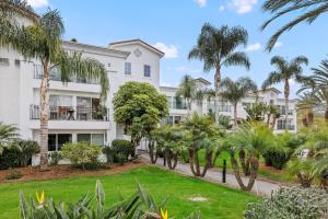 ein Gebäude mit Palmen davor in der Unterkunft 604 Gorgeous Renovated Condo, Steps to Omni Spa, Golf, Tennis, PFC & Exclusive Building Pool in Encinitas