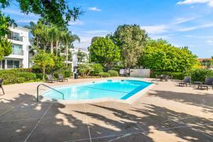 ein Swimmingpool mit Stühlen und einem Gebäude in der Unterkunft 604 Gorgeous Renovated Condo, Steps to Omni Spa, Golf, Tennis, PFC & Exclusive Building Pool in Encinitas