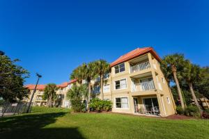 duży budynek apartamentowy z palmami w parku w obiekcie Parc Corniche Condominium Suites w Orlando