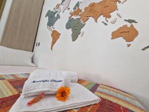 a bed with towels and a world map on the wall at Meraviglia d'Otranto in Otranto