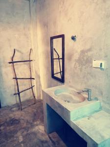 a bathroom with a sink and a mirror on the wall at Tiger Villa in Midigama East