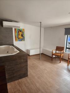 a bathroom with a tub and a table and a chair at MOTEL PREMIER in Guadalajara
