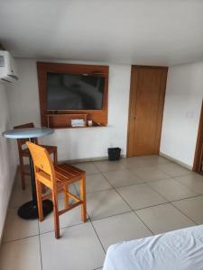 グアダラハラにあるMOTEL PREMIERのテーブル、椅子、テレビが備わる客室です。