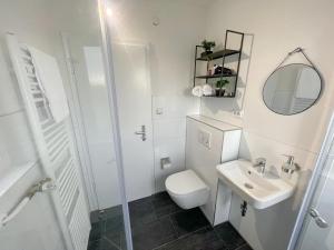Baño blanco con aseo y lavamanos en Perfekte 1,5 Wohnung Zentral in Leonberg gegenüber Einkaufzentrum, en Leonberg