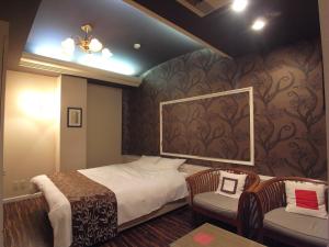 pokój hotelowy z łóżkiem i 2 krzesłami w obiekcie ホテル カルネヴァール 男塾ホテルグループ w mieście Himeji