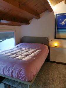uma cama num pequeno quarto com uma janela em Mansarda centro storico em Pordenone